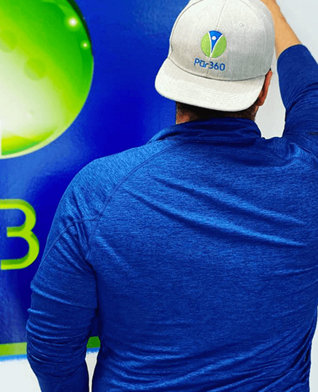Pur360 technician wearing a blue shirt with a Pur360 branded hat