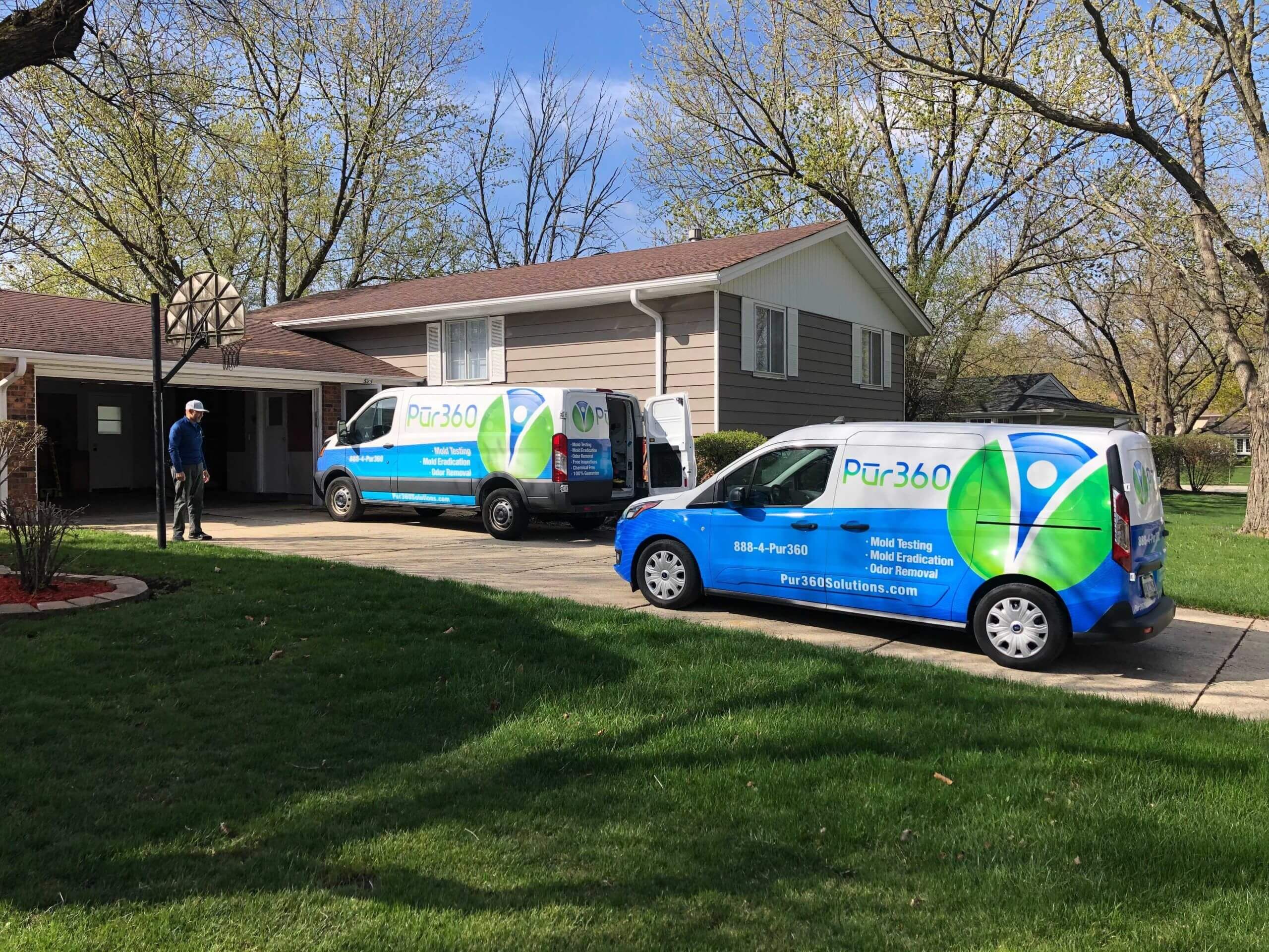 Two Pur360 service vans parked outside on the driveway of a home