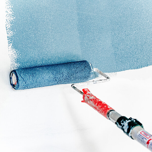 Painting a white wall blue using a paint-roller