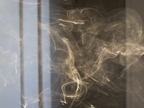 Closeup of cigarette smoke inside a home