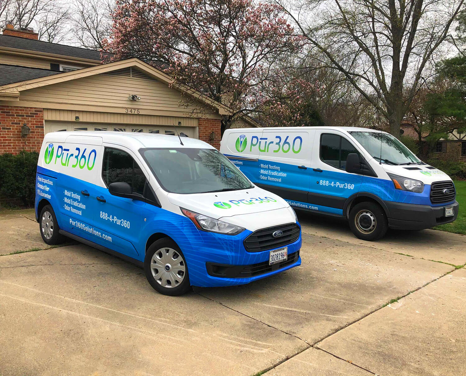 Two Pur360 service vans parked outside on the driveway of a home